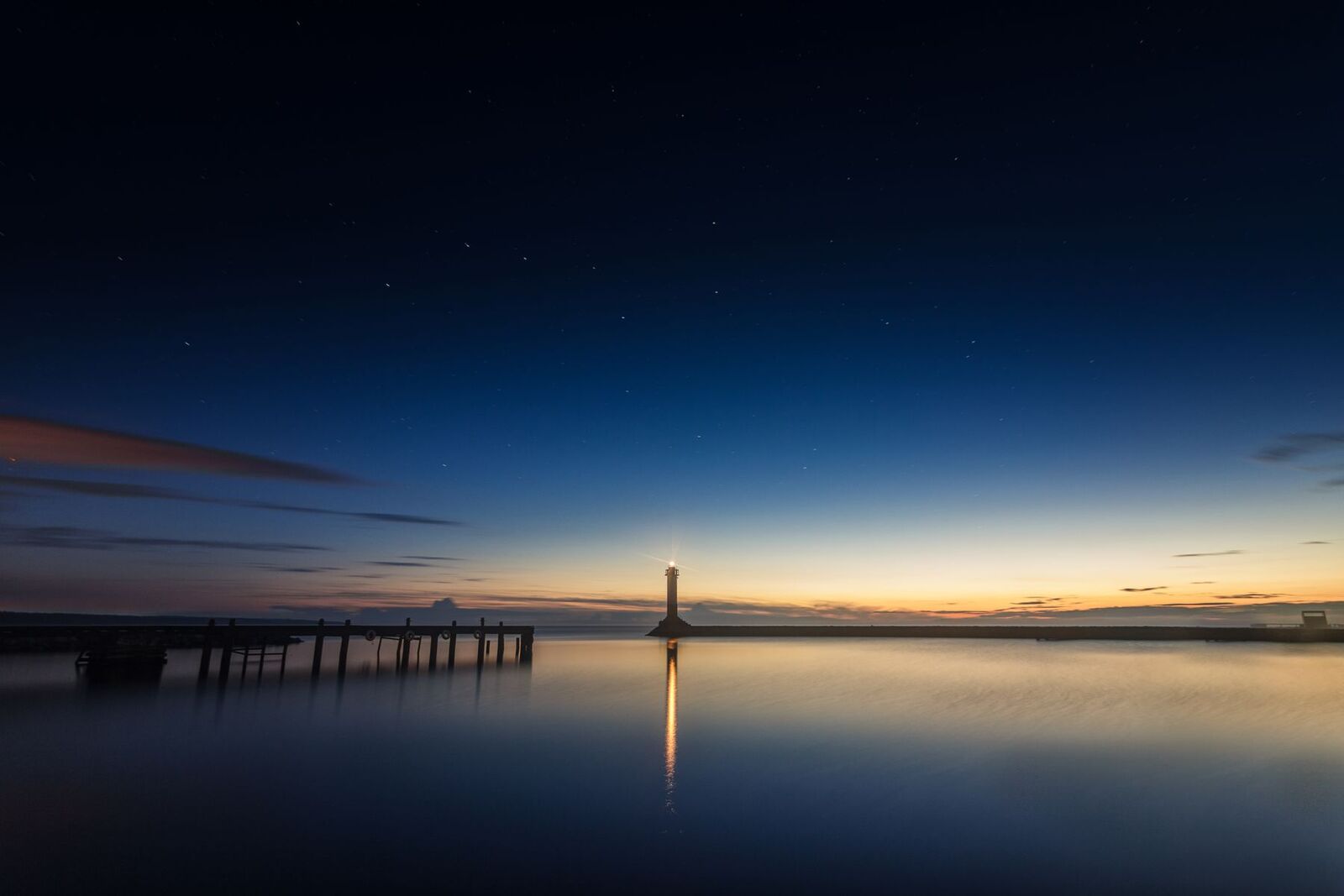 A lighthouse at dusk over still water